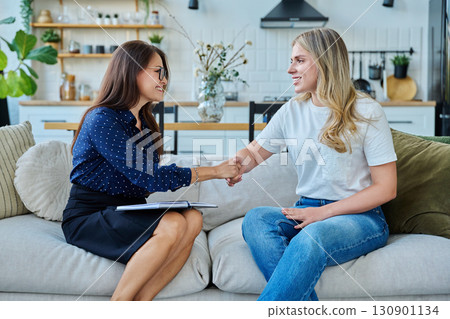 Female social worker working at home with young woman Female social worker working at home with young woman 130901134
