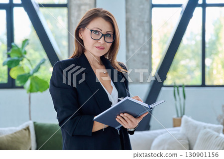 Portrait of serious middle-aged confident business woman with notebook Portrait of serious middle-aged confident business woman with notebook 130901156