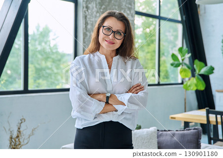 Portrait confident middle aged businesswoman posing with crossed arms Portrait confident middle aged businesswoman posing with crossed arms 130901180