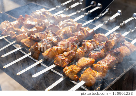Juicy sizzling shish kebab grilling on a charcoal grill Juicy sizzling shish kebab grilling on a charcoal grill 130901228