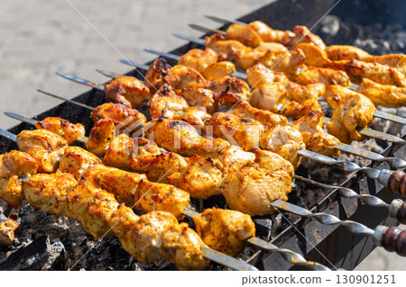 Juicy sizzling shish kebab grilling on a charcoal grill Juicy sizzling shish kebab grilling on a charcoal grill 130901251