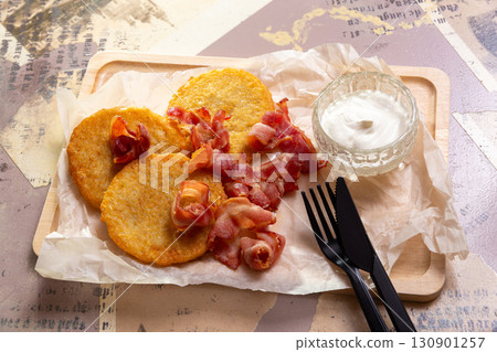 A portion of golden potato pancakes, fried with crispy bacon 130901257