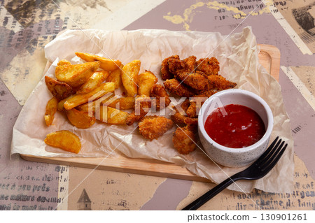 Crispy chicken nuggets and french fries 130901261