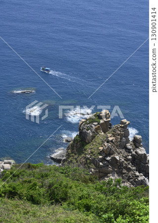 Aerial view of a steep mountain cliff, fishing boat and the South China Sea in Vietnam Aerial view of a steep mountain cliff, fishing boat and the South China Sea in Vietnam 130901414