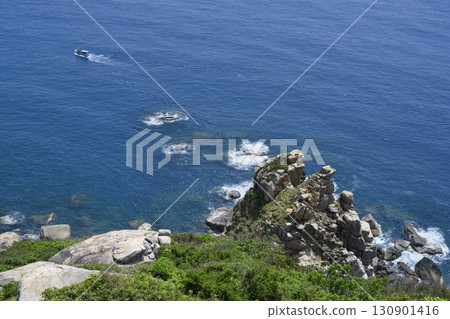 Aerial view of a steep mountain cliff, fishing boat and the South China Sea in Vietnam 130901416