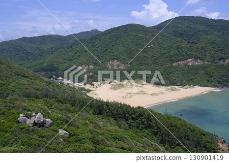 Bay surrounded by mountains with sandy beach and small fishing boat in South China Sea in Vietnam 130901419