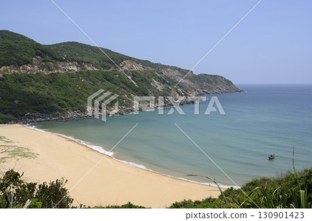A bay, mountains with deserted sandy beach and small fishing boat in the South China Sea in Vietnam 130901423