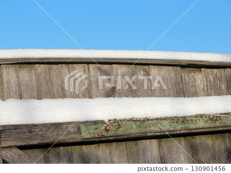 Layer of snow on the fence. Winter has come. Frosty weather. Countryside life Layer of snow on the fence. Winter has come. Frosty weather. Countryside life 130901456