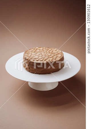 Chocolate cake with heart shaped decor on stand, minimal brown background 130901612