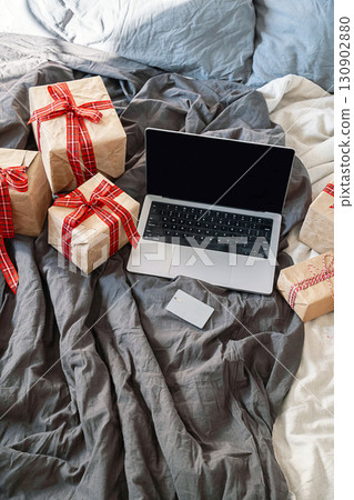 Laptop, credit card, and gifts on bed. Online shopping and purchase concept. Laptop, credit card, and gifts on bed. Online shopping and purchase concept. 130902880