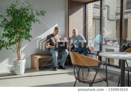 Two knowledgeable professionals collaborating effectively together in a modern workspace setting Two knowledgeable professionals collaborating effectively together in a modern workspace setting 130903920
