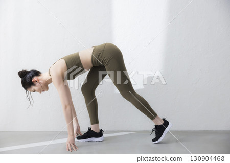 A woman stretching in training wear 130904468