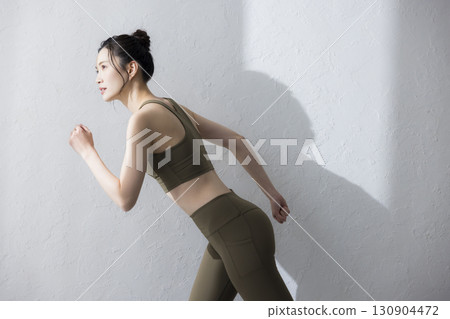 一個穿著訓練服伸展的女人 130904472