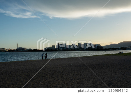 Couple walking along the beach at sunset Couple walking along the beach at sunset 130904542