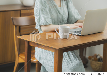 A woman watching a computer in a room A woman watching a computer in a room 130904674