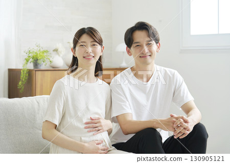 Couple in their 20s, pregnant wife, portrait, home, looking at camera 130905121
