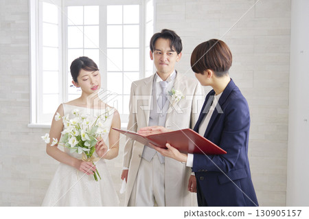 A wedding celebrant and the bride and groom having a meeting while worrying A wedding celebrant and the bride and groom having a meeting while worrying 130905157