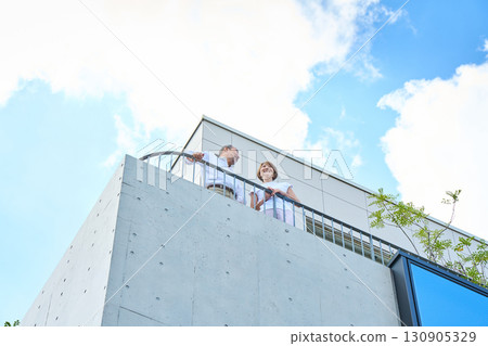 A middle-aged couple standing on the balcony. A middle-aged couple standing on the balcony. 130905329