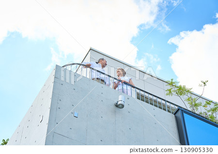 A middle-aged couple standing on the balcony. A middle-aged couple standing on the balcony. 130905330