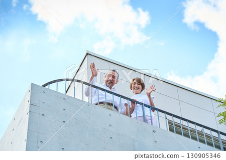 A middle-aged couple standing on the balcony. 130905346