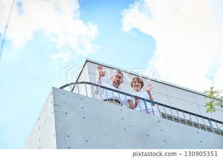 一對富有的中年夫婦站在陽台上 130905351