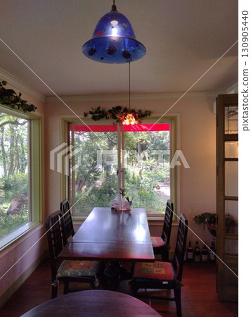A stylish cafe with a view of the green scenery from the window 130905440