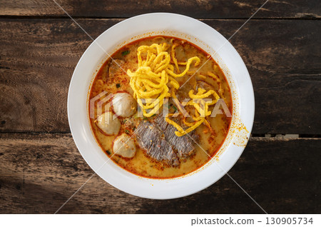 A beef Khao soi (Northern Thai Coconut Curry Noodle Soup) served on table. Khao soi is one of the most popular Thai dishes to eat in northern Thailand, especially in Chiang Mai and Chiang Rai. A beef Khao soi (Northern Thai Coconut Curry Noodle Soup) served on table. Khao soi is one of the most popular Thai dishes to eat in northern Thailand, especially in Chiang Mai and Chiang Rai. 130905734