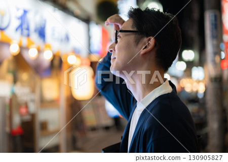 A man walking through a restaurant district 130905827