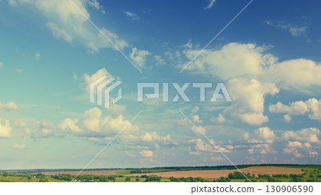 A Beautiful and Cloudy Sky Over an Expansive Green Landscape That Captivates the Eye 130906590