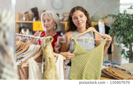 Elderly and young women choosing summer clothes in store 130907070