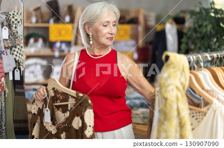 Positive mature woman choosing something for summer in clothing store Positive mature woman choosing something for summer in clothing store 130907090