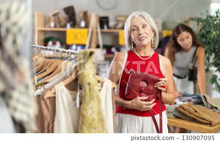 Elderly women choosing high heel shoes in store 130907095