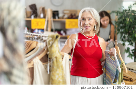 Elderly woman chooses top in clothing store 130907101
