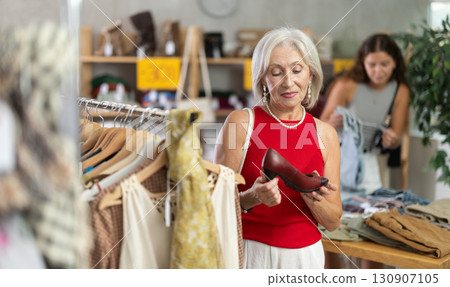 Elderly women choosing high heel shoes in store 130907105
