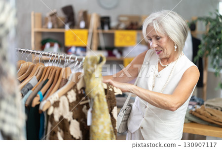Elderly woman choosing summer clothes in store 130907117