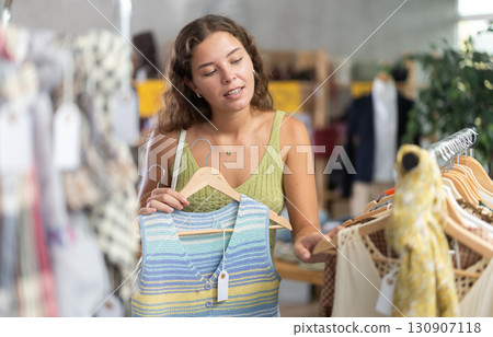 Young woman choosing vest in clothing store 130907118