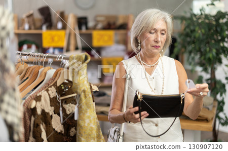 Elderly women choosing handbag in store 130907120