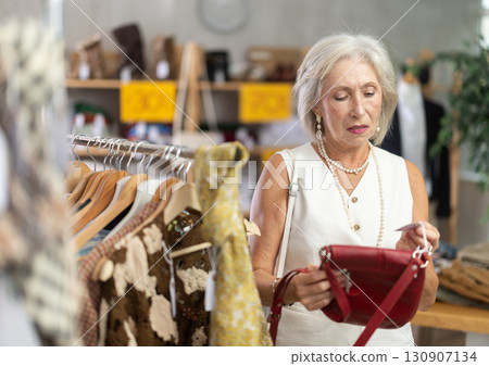 Elderly women choosing handbag in store 130907134