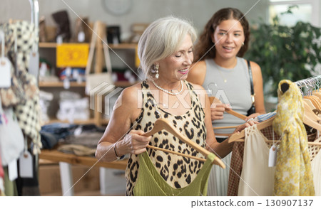 Two positive women choosing something for summer in clothing store Two positive women choosing something for summer in clothing store 130907137