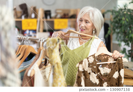 Elderly woman choosing summer clothes in store 130907138