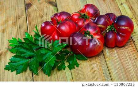 Beefsteak tomatoes and parsley on wooden table 130907222