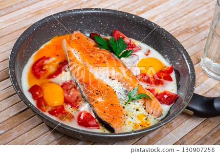 Fried eggs with salmon and cherry tomato 130907258