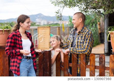 Smiling neighbors talking at backyard garden 130907360