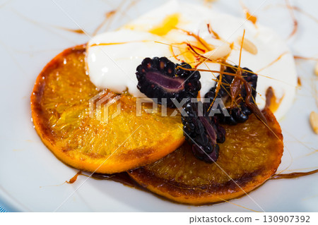 Glazed orange with caramel, dewberries and yogurt 130907392