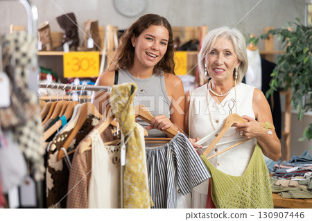 Two happy women of different ages choose summer clothes in fashion boutique 130907446