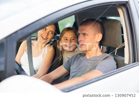 Portrait of happy family of three in car salon 130907452