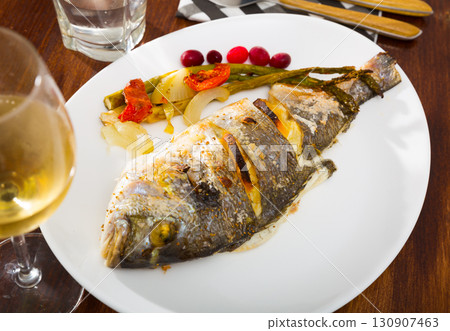 Whole baked dorada with vegetable garnish 130907463