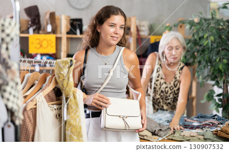 Young women choosing handbag in store 130907532