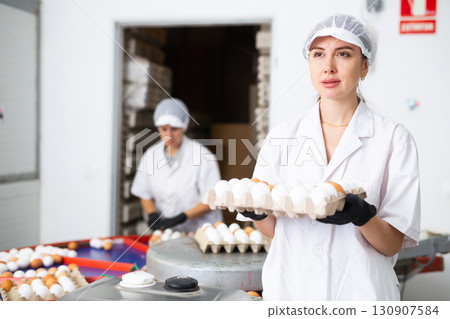 Woman holding carton tray with fresh eggs on farm 130907584