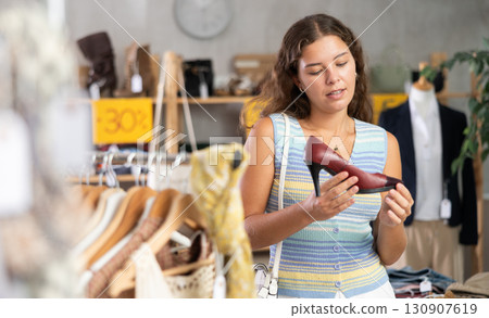 Young woman choosing high heel shoes in store 130907619